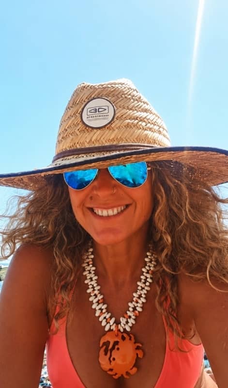 Chica sonriente con sombrero y gafas de sol azules con Collar doble de cuentas de resina blancas y cangrejo naranja