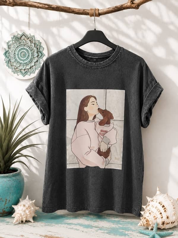 Camiseta gris oscuro de manga corta con efecto lavado e ilustración central de una mujer abrazando a un perro salchicha.