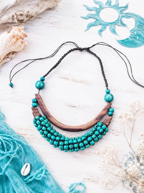 Collar étnico artesanal con barra de madera curvada y filas de cuentas de madera verde