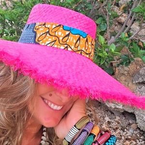 Sombrero playero tipo pamela color fucsia decorado con banda de tejido estampado estilo africano