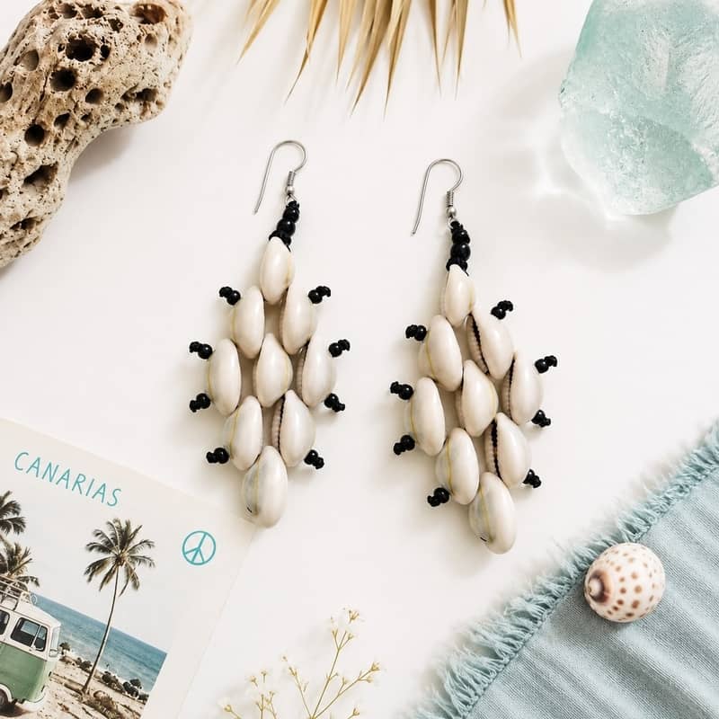 Pendientes largos de estilo boho formados por conchas cauri naturales en forma de rombo con pequeñas cuentas negras