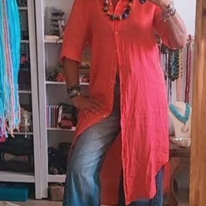 Silvia de Sawabona posando en el espejo con kimono de lino rojo abierto collares artesanales y vaqueros