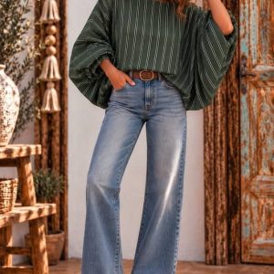 • Modelo posando con blusa de rayas verdes y mangas murciélago abullonadas con vaqueros campana en Sawabona.