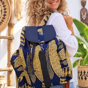 Mochila de tela africana artesanal en color azul marino con estampado geométrico amarillo, solapa de polipiel y flecos marrones de la tienda Sawabona